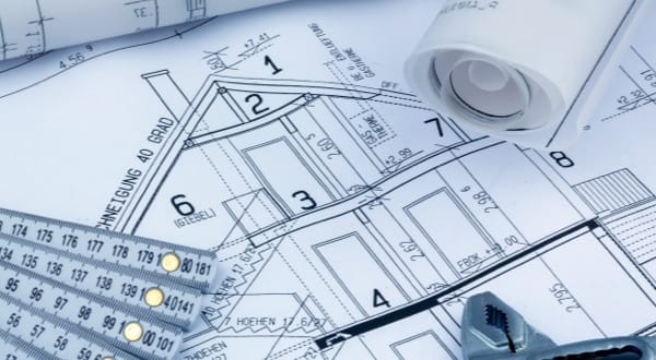 Plan architectural détaillé avec des outils de dessin et des rouleaux de plans.